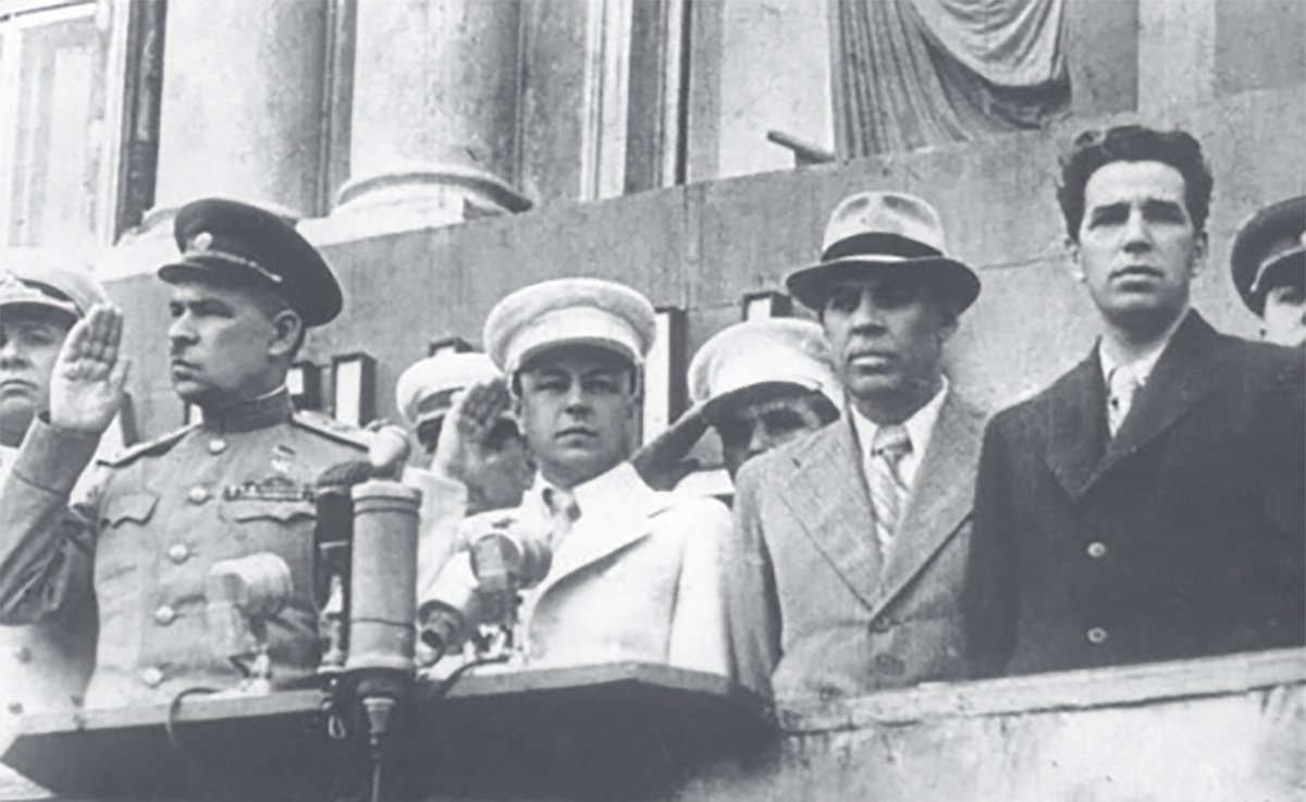 Председатель исполкома Ленинградского городского Совета депутатов трудящихся П. С. Попков (второй справа) и первый секретарь Ленинградского обкома и горкома ВКП(б) А. А. Кузнецов (первый справа) на трибуне на Дворцовой площади, Ленинград, 1945 год. Фото: mirpeterburga.ru