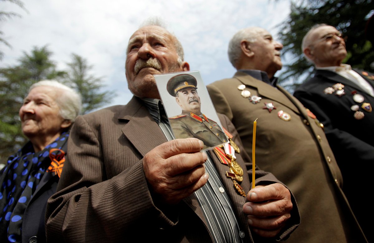 Ветеран держит портрет Иосифа Сталина во время празднования Дня Победы в Тбилиси, 9 мая 2012 года. Фото: David Mdzinarishvili / Reuters / Scanpix / LETA