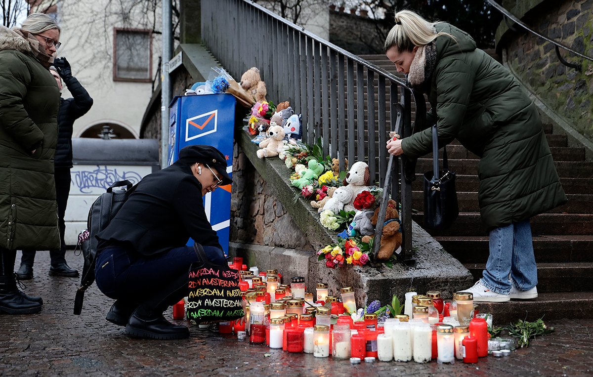 Люди несут цветы и свечи в парке, где 22 января в Ашаффенбурге, Германия, 2025 года в результате нападения с ножом были убиты два человека. Фото: Ronald Wittek / EPA-EFE