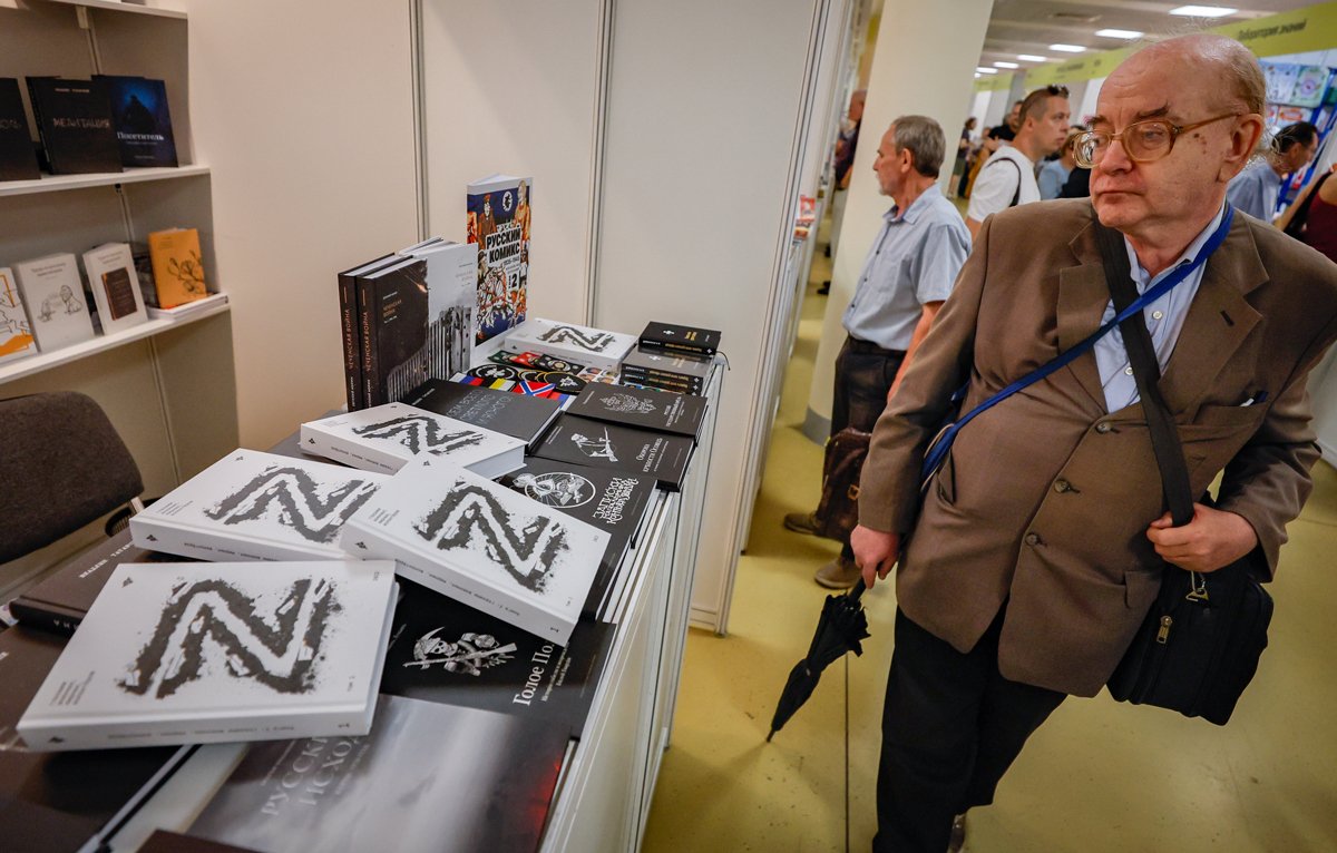 Посетитель рассматривает книги на Московской книжной ярмарке, 4 сентября 2024 года. Фото: Юрий Кочетков / EPA