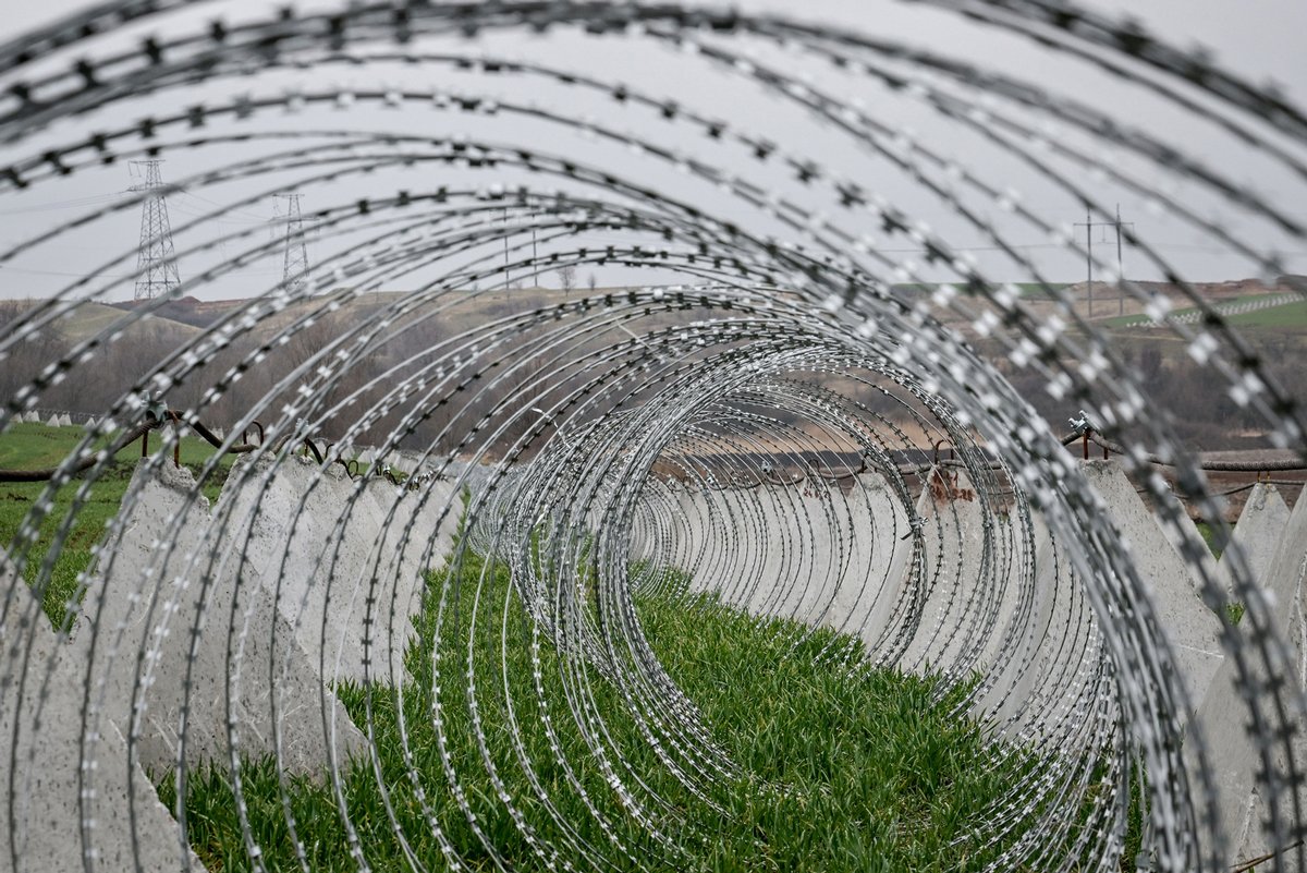Проволочные заграждения и противотанковые ежи на поле с ячменём в Запорожской области, 17 марта 2025 года. Фото: Dmytro Smolienko / Ukrinform / ZUMA Press Wire / SplashNews.com / Vida Press