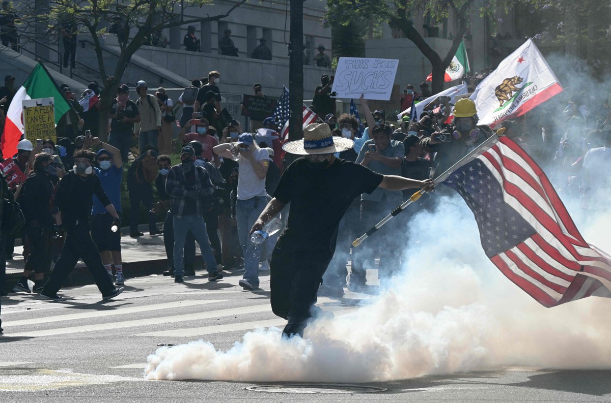 Протестующий пинает газовую гранату во время попытки полиции разогнать демонстрантов в Лос-Анджелесе, Калифорния, 14 июня 2025 года. Фото: Ronaldo Schemidt / AFP / Scanpix / LETA