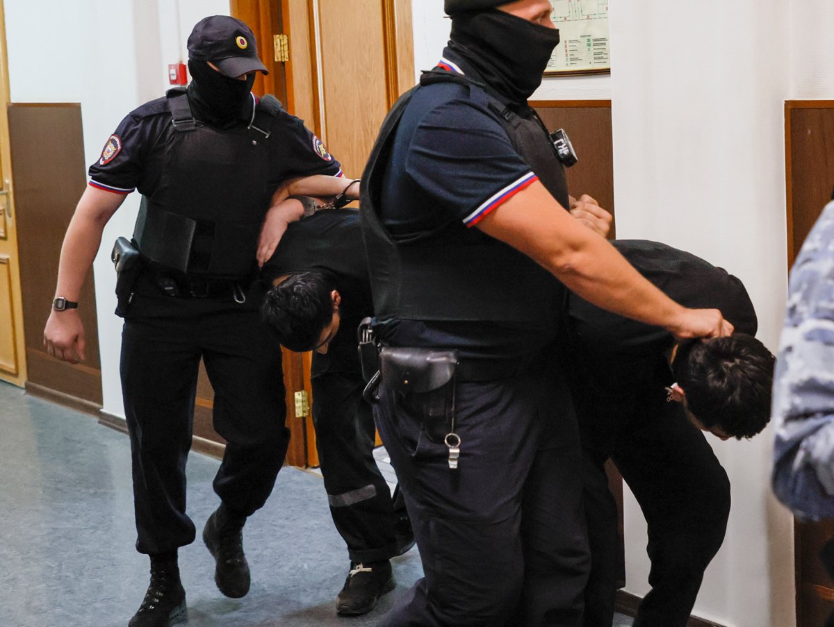 Сотрудники полиции сопровождают обвиняемых по делу о теракте в Crocus City Hall перед заседанием Басманного суда, Москва, 19 августа 2024 года. Фото: Юрий Кочетков / EPA