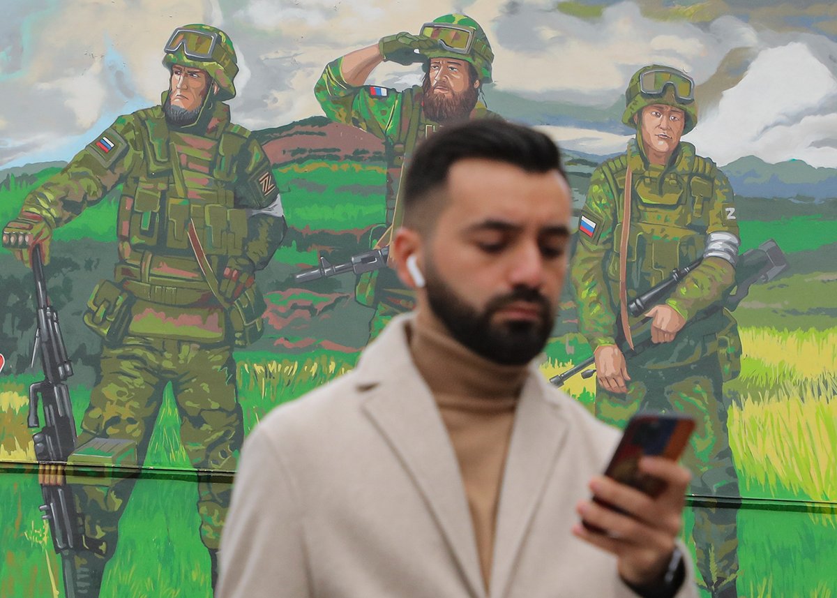 Мужчина проходит мимо жилого дома, украшенного фреской с изображением российских войск, в Москве, Россия, 21 сентября 2022 года. Фото: Максим Шипенков / EPA