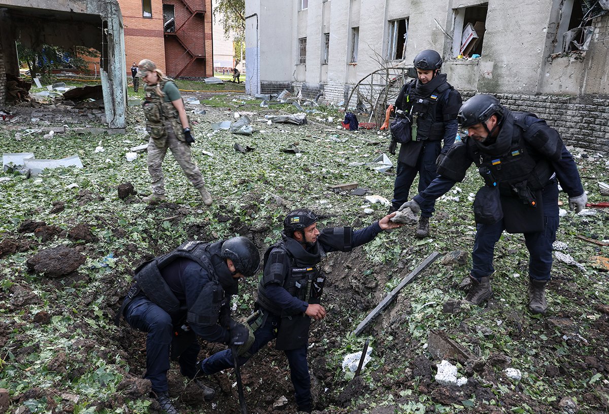 Украинские эксперты работают на месте удара беспилотника по жилому зданию в Харькове, на северо-востоке Украины, 7 июля 2025 года. Фото: Sergey Kozlov / EPA