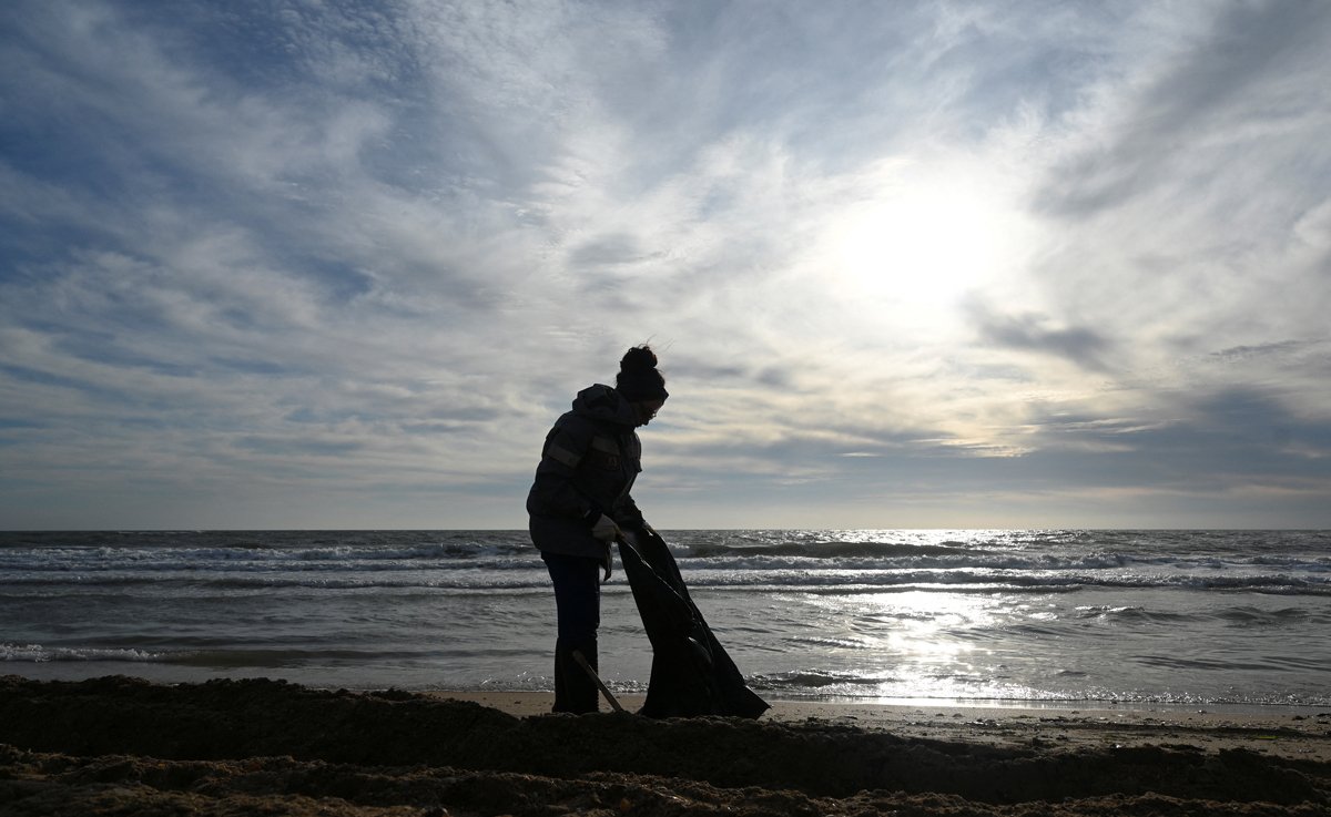 Волонтёр убирает мазут на пляже в Анапе, 21 декабря 2024 года. Фото: Сергей Пивоваров / Reuters / Scanpix / LETA