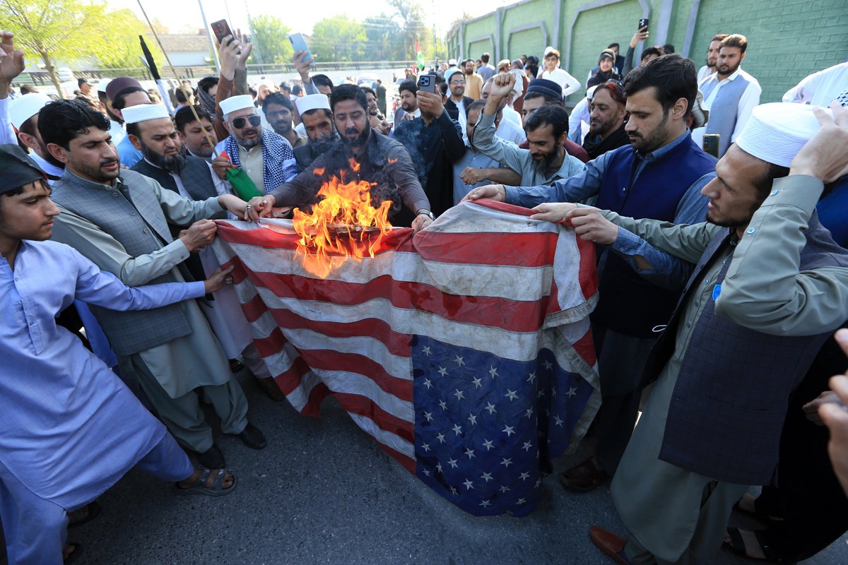 Сторонники Jamaat-e-Islami сжигают флаг США во время акции протеста у здания американского консульства в Пешаваре, Пакистан, 21 марта 2025 года. Фото: Arshad Arbab / EPA